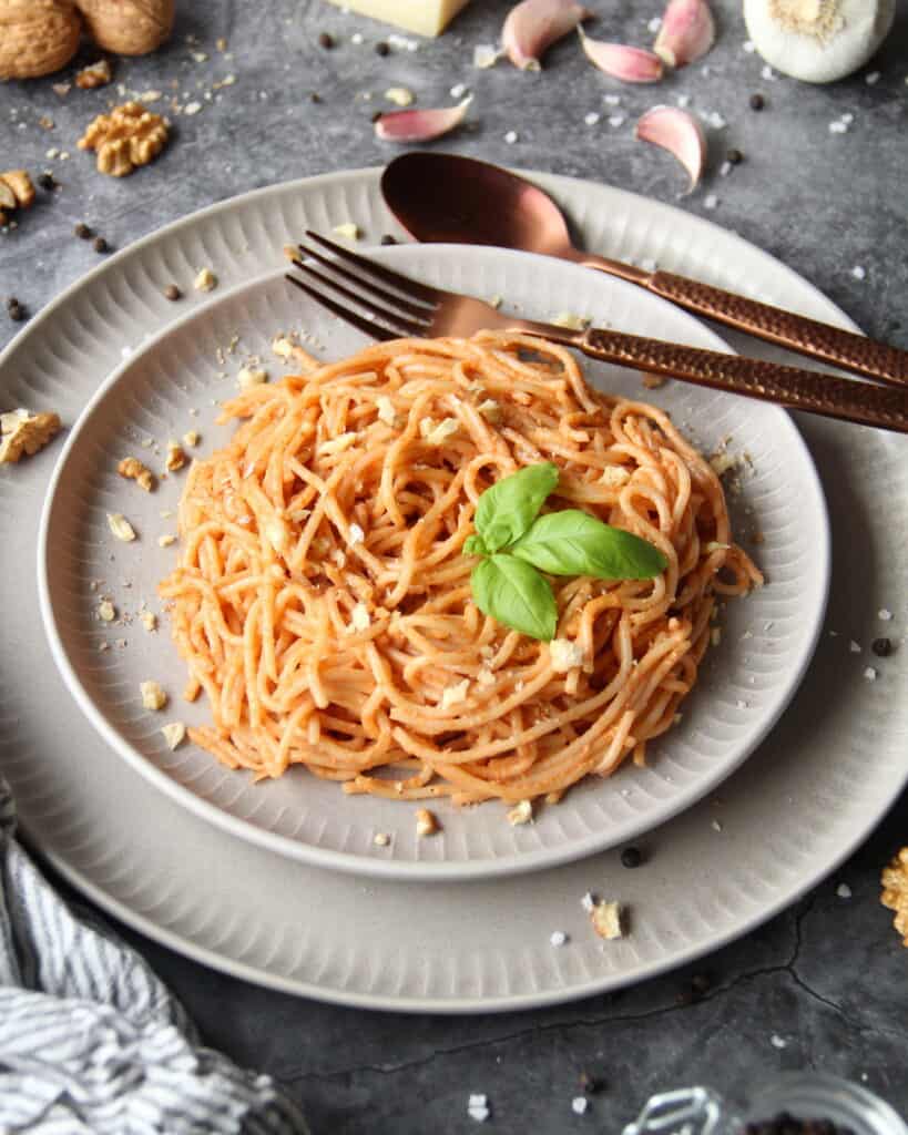 Ein Teller mit Spaghetti mit Walnuss-Pesto. Aussen herum Deko.