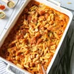 Eine weisse Auflaufform mit Nudel-Schinken-Gratin.