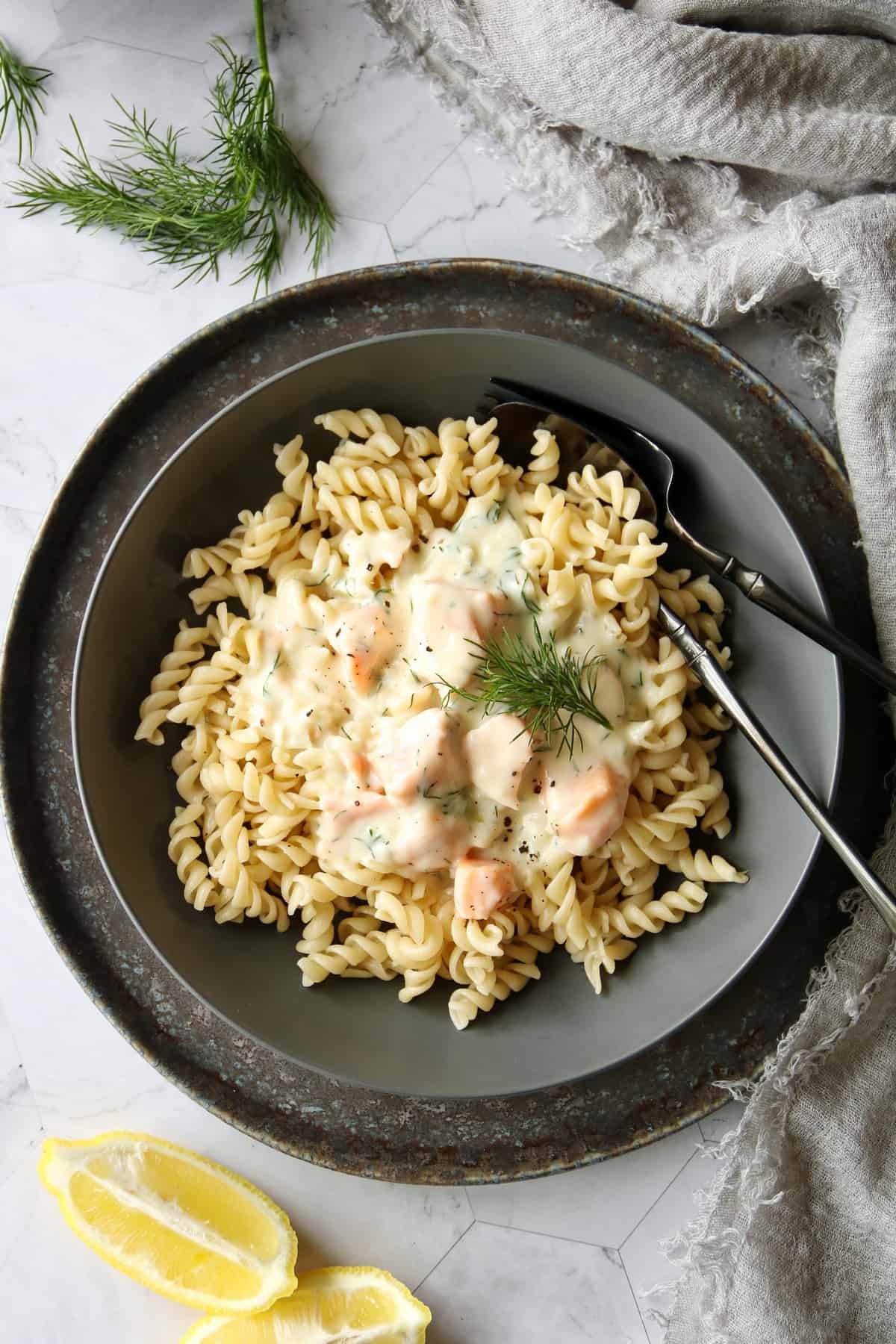 A plate of pasta with salmon and cream sauce.