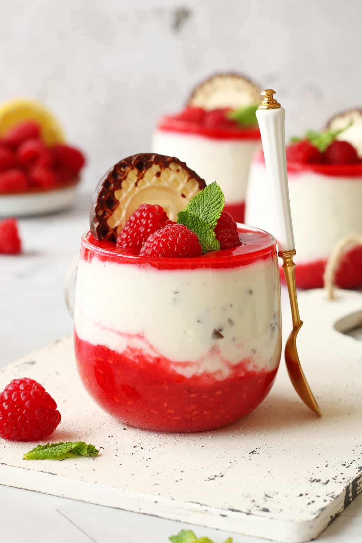 A glass of Dickmann's dessert with raspberries.