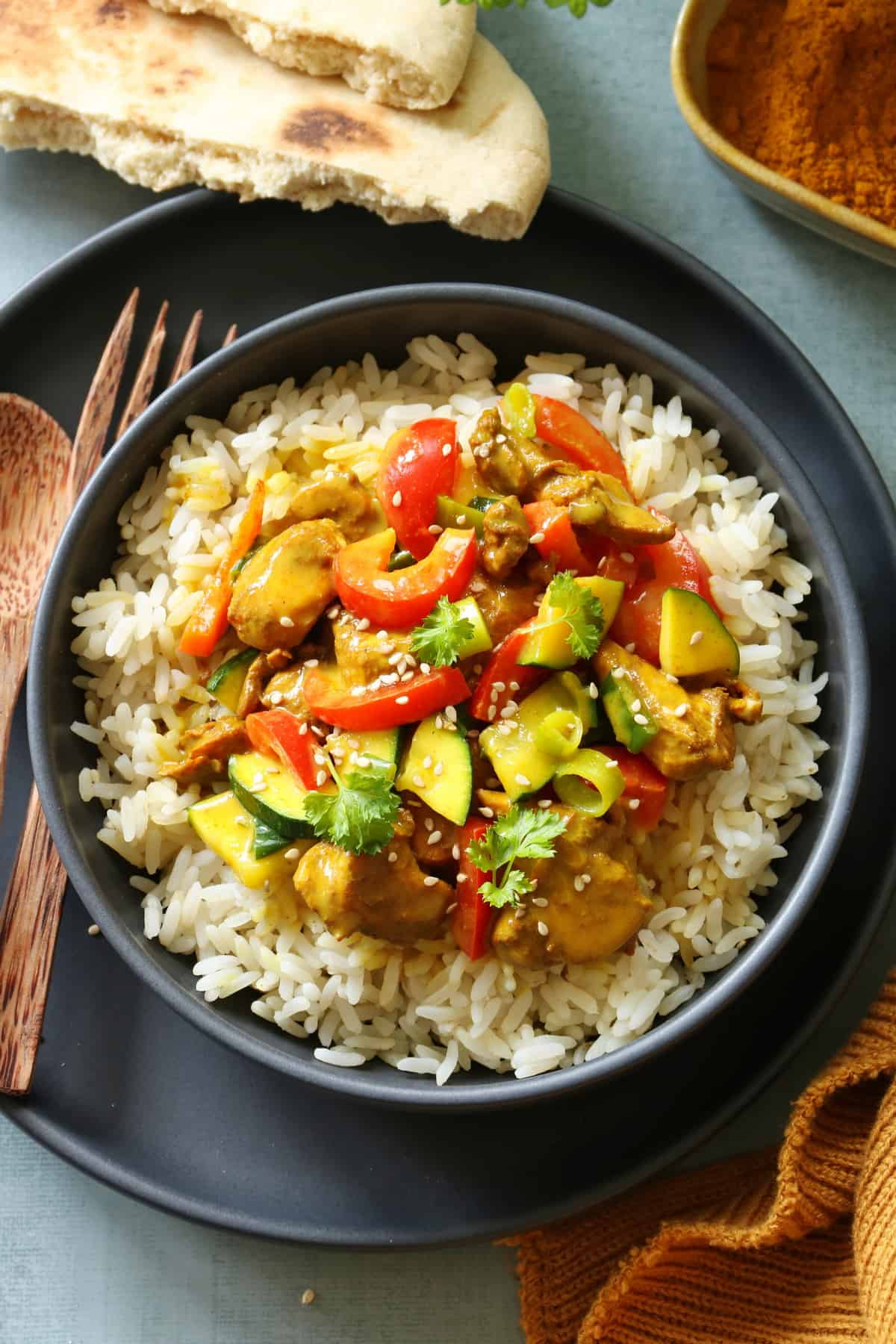 Ein Teller mit Hähnchen Curry und Reis.