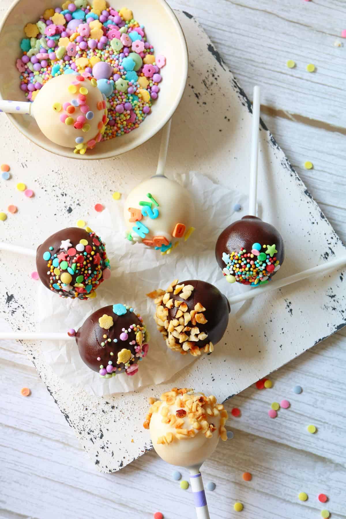 Mehrere Cake Pops auf einem Holzbrettchen.