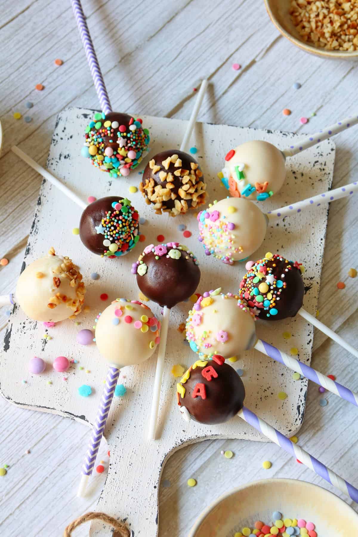 Cake Pops auf einem weißen Holzbrett.