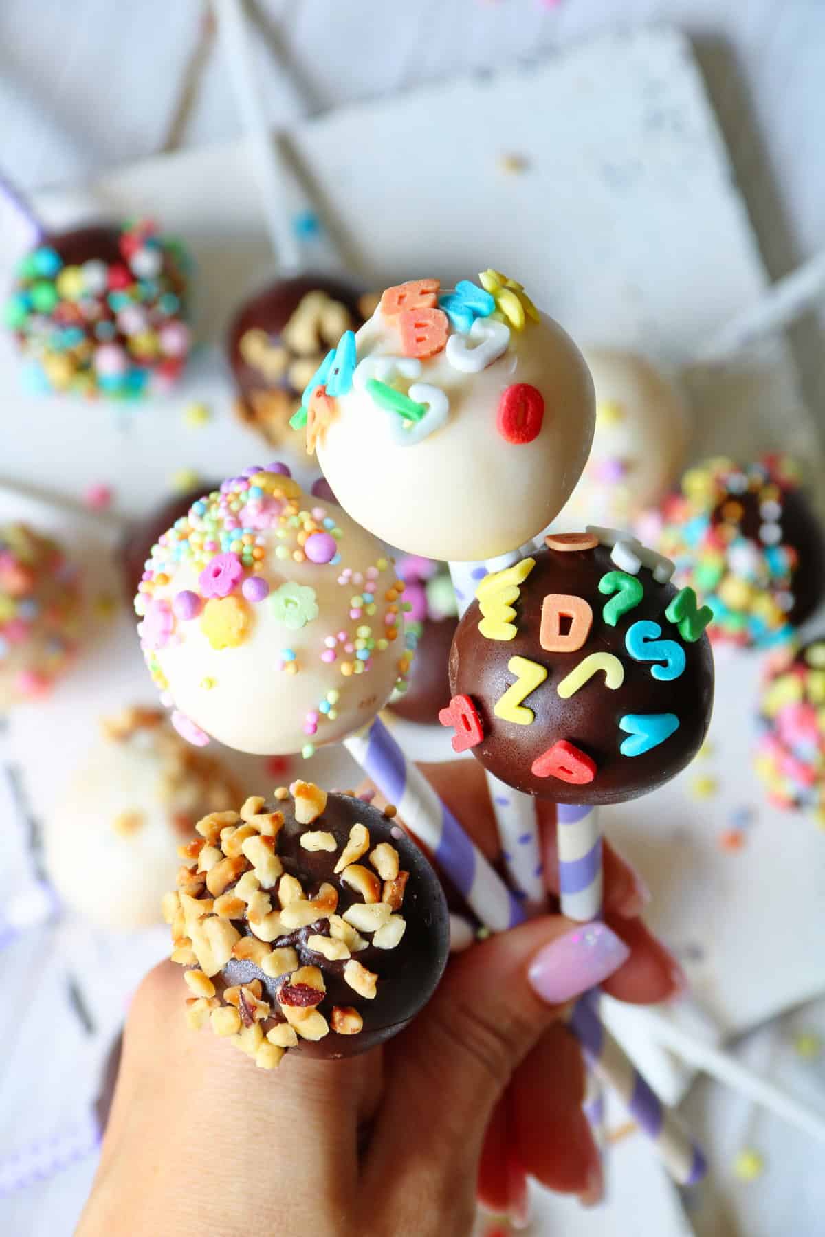 Eine Hand hält mehrere Cake Pops.