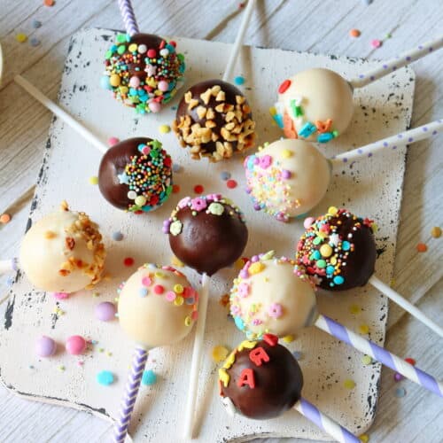 Cake Pops auf einem weißen Holzbrett.