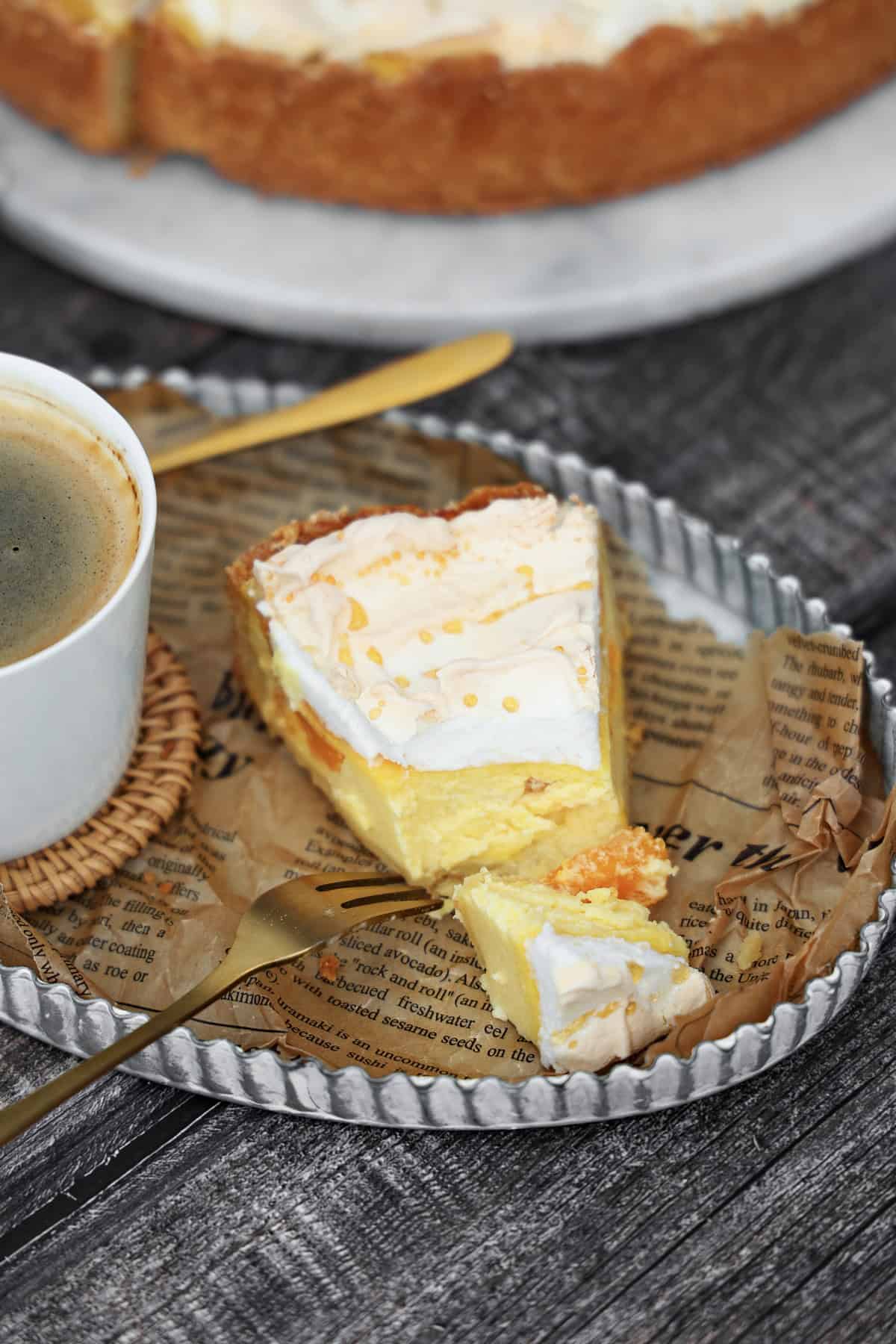 Ein Stück Käsekuchen mit Mandarinen und Baiser.