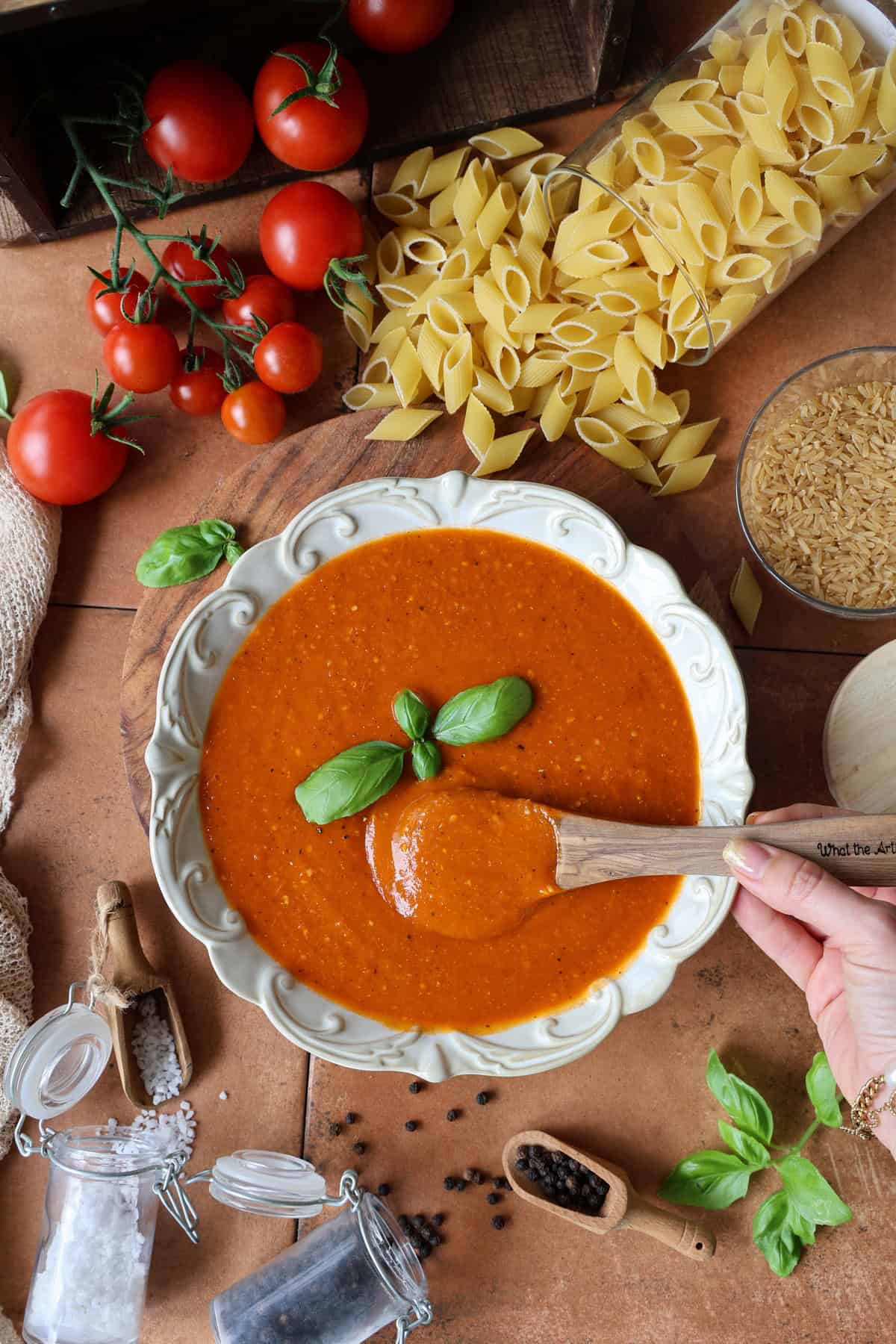 Eine Schale mit ofengerösteter Tomatensoße. Aussen herum Deko.