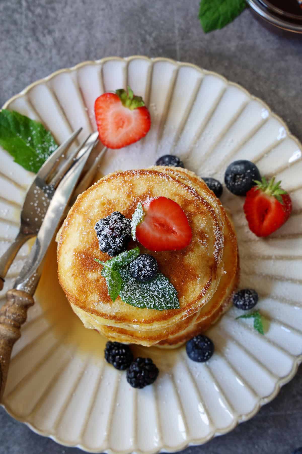 Ein Stapel Pancakes mit Früchten auf einem Teller.