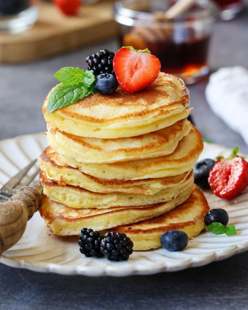 Ein Stapel Pancakes mit Früchten auf einem Teller.