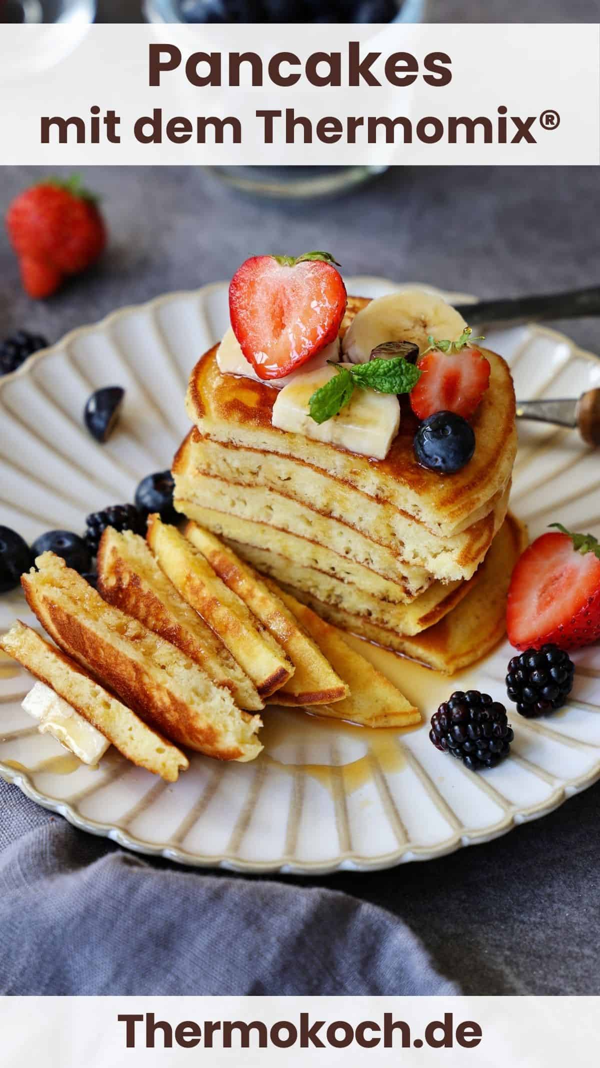 Ein Stapel angeschnittener Pancakes mit Früchten auf einem Teller.