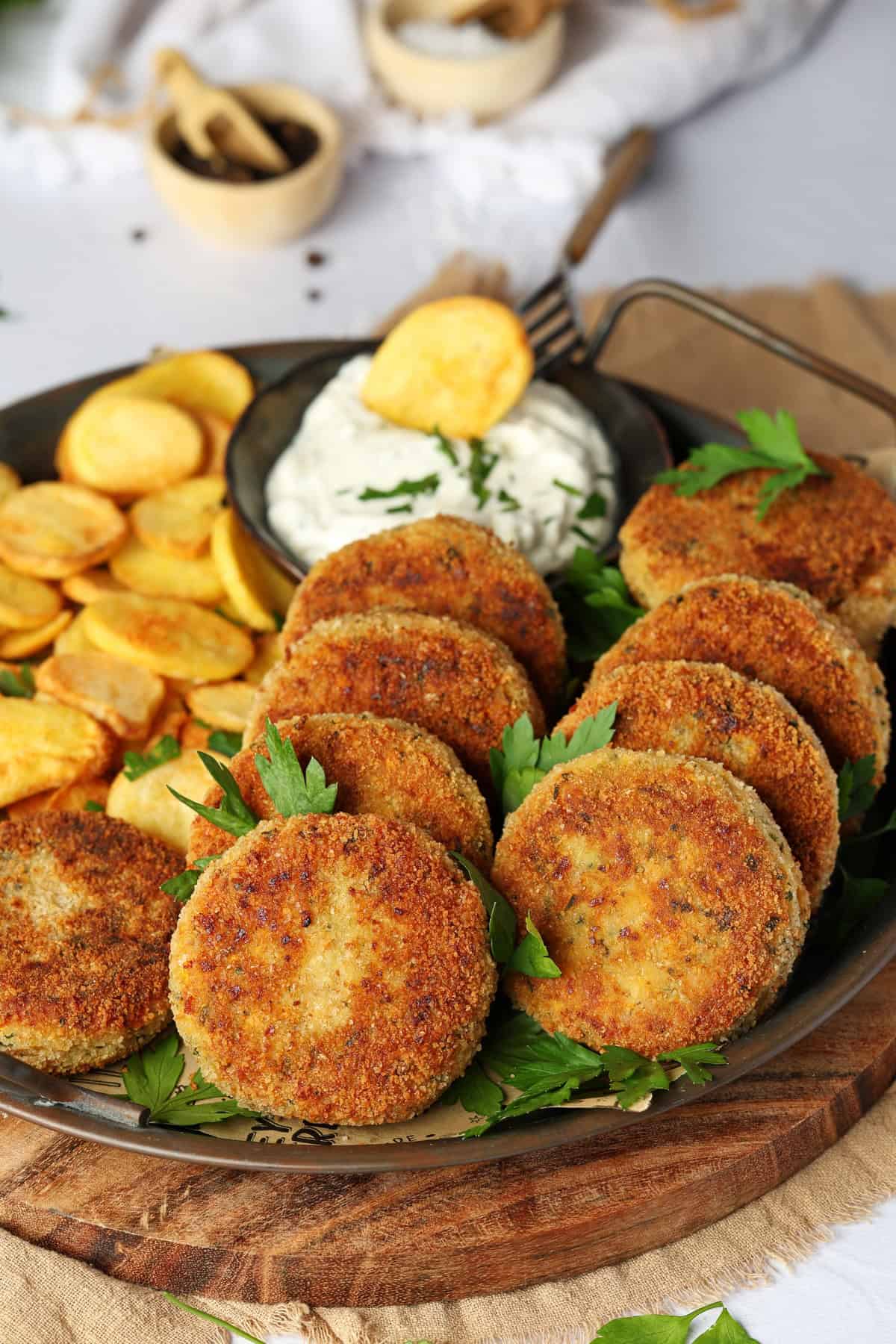 Ein Teller mit Gemüsefrikadellen, Pommes und einem Dip.