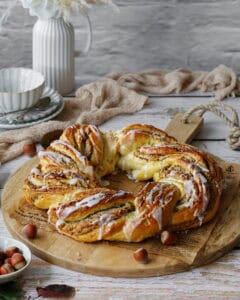 Ein Nusskranz mit Marzipan auf einem Holzbrett.