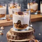 Ein Glas mit Toffifee Dessert, das auf mehreren runden Holzscheiben steht.