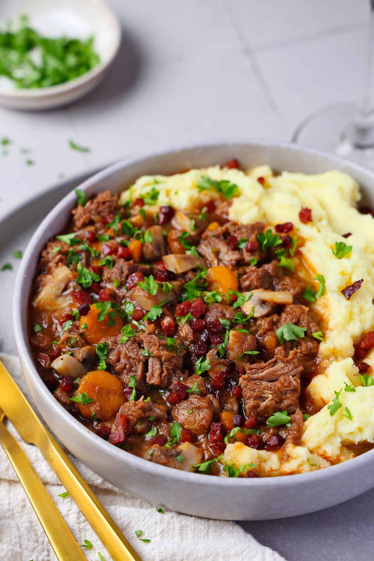 Close-up of a plate of Boeuf Bourguignon served with creamy mashed potatoes.