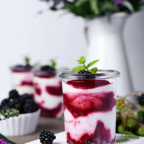 Ein Glas mit Brombeer-Mascarpone-Trifle im Glas.