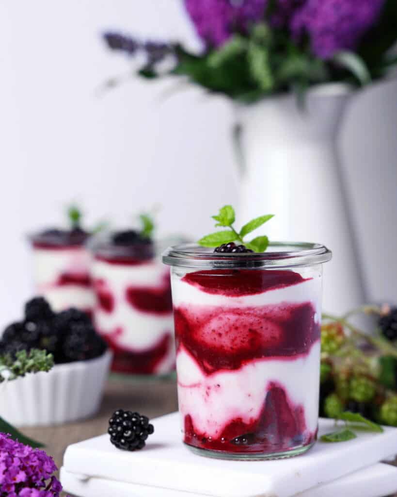 Ein Glas mit Brombeer-Mascarpone-Trifle im Glas.