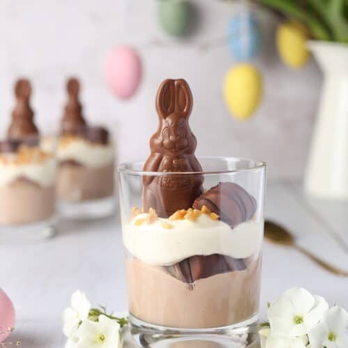 Zweifarbig geschichtetes Bueno Dessert im Glas, dekoriert mit Schokohase und Haselnüssen zu Ostern.