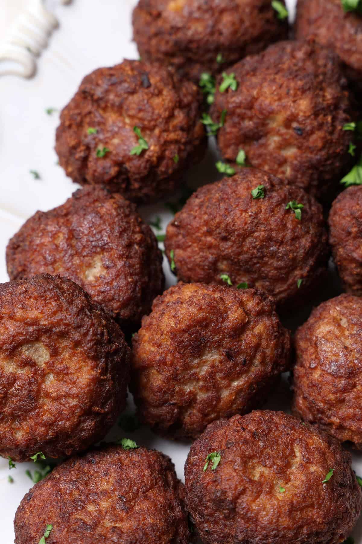 A close-up of meatballs on a white background.
