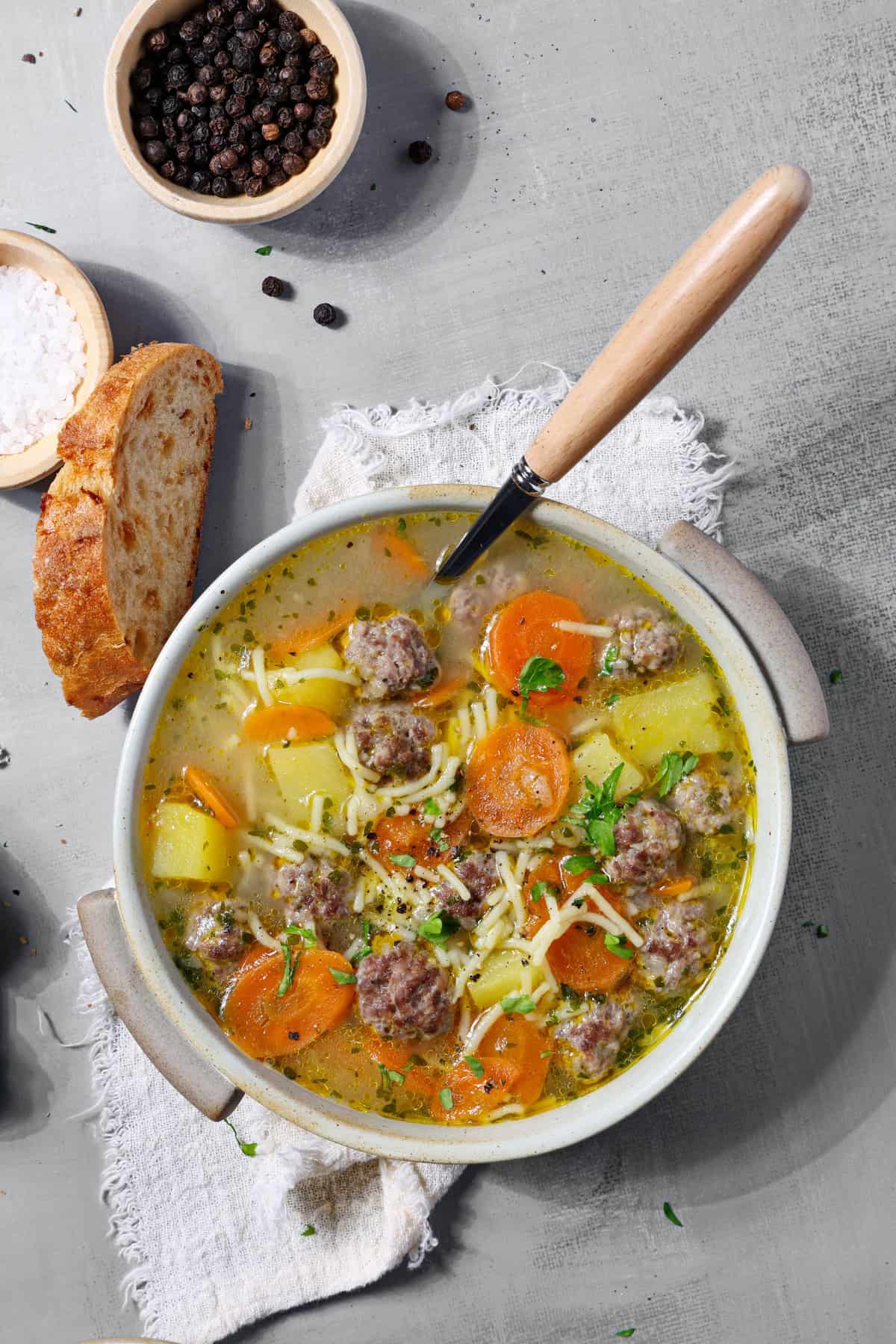 Eine Schalte mit Frikadellen-Suppe. Darüber eine Scheibe Brot.