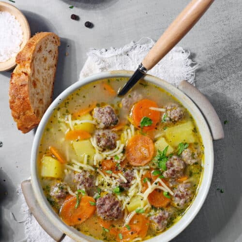 Eine Schalte mit Frikadellen-Suppe. Darüber eine Scheibe Brot.