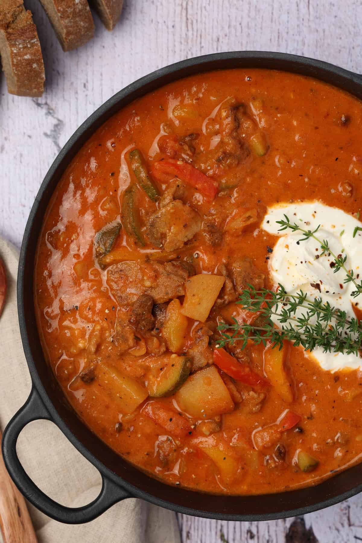A close-up of a black pot filled with gyros stew.