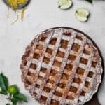 Ein Apple Pie auf einem runden Holztablett. Darüber Deko.
