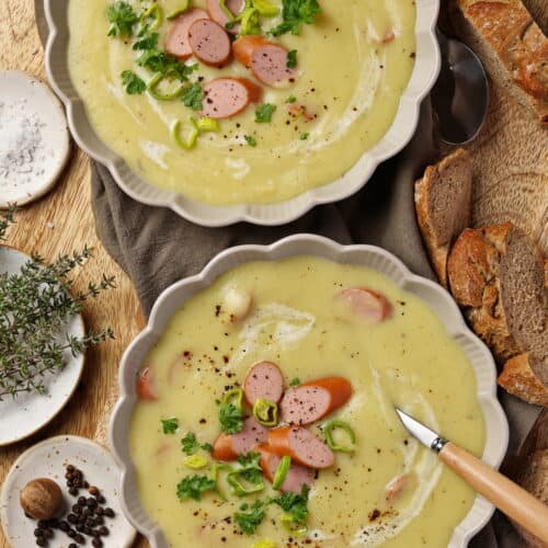 Zwei Suppenteller mit Kartoffel-Pastinaken-Suppe mit Wienerle.