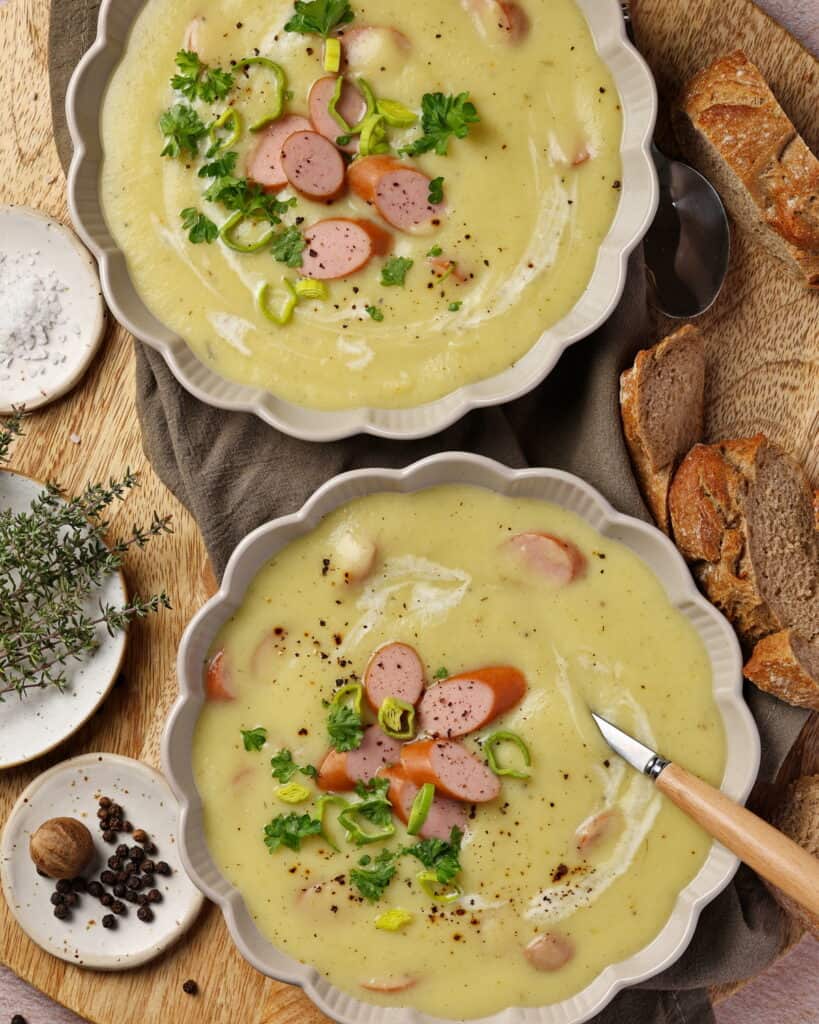 Zwei Suppenteller mit Kartoffel-Pastinaken-Suppe mit Wienerle.