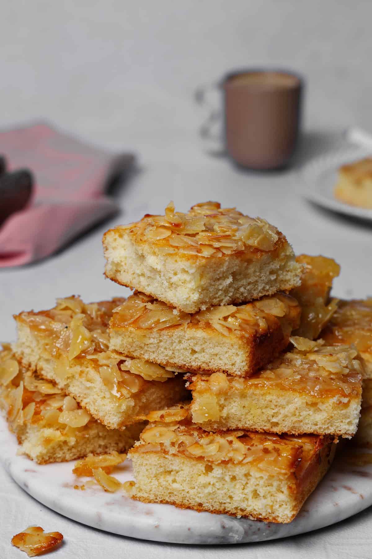 Mehrere Stücke Mandel-Butterkuchen, gestapelt auf einer runden Marmorscheibe.