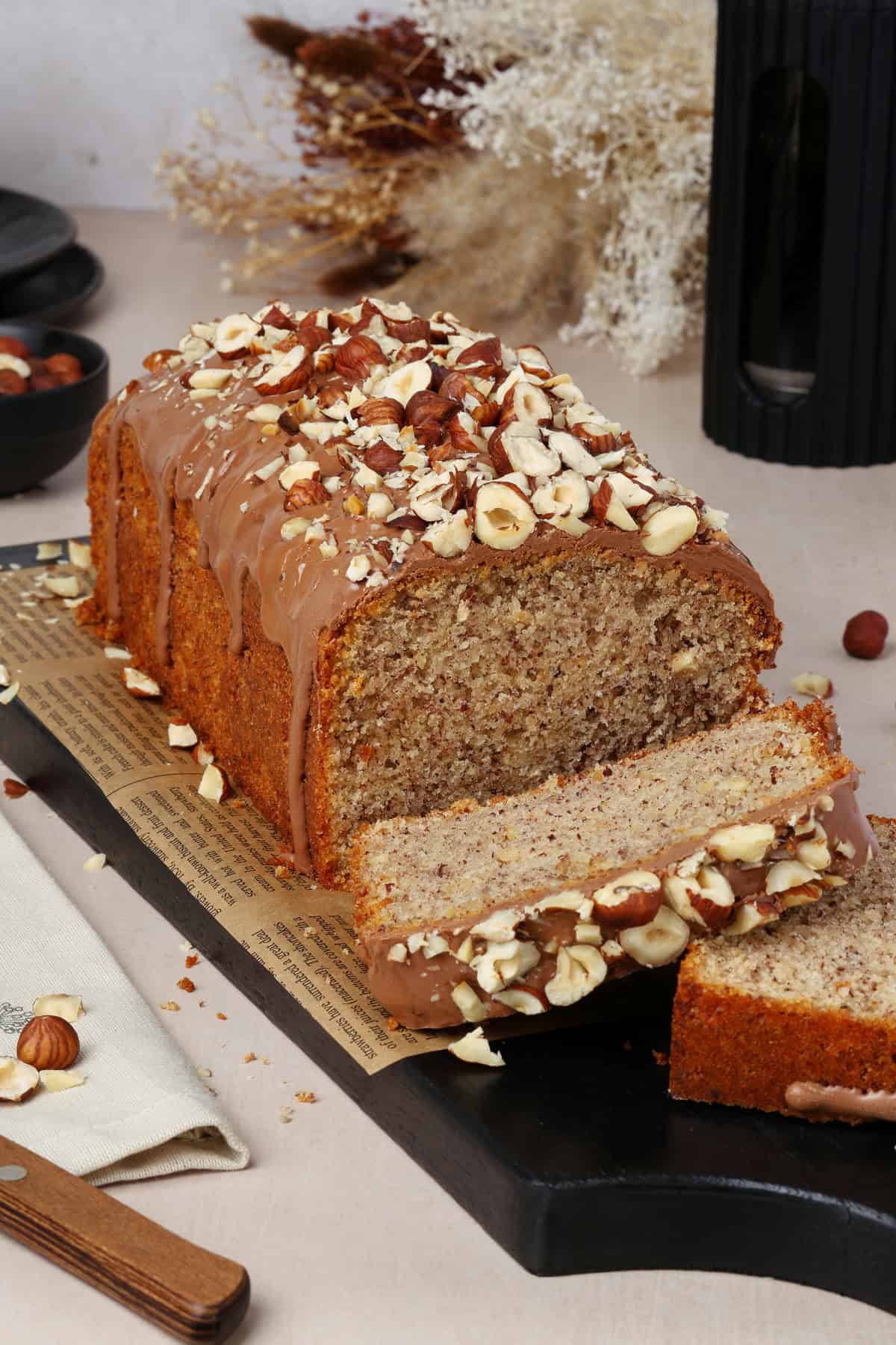 A sliced nut cake beautifully plated on a dessert table.