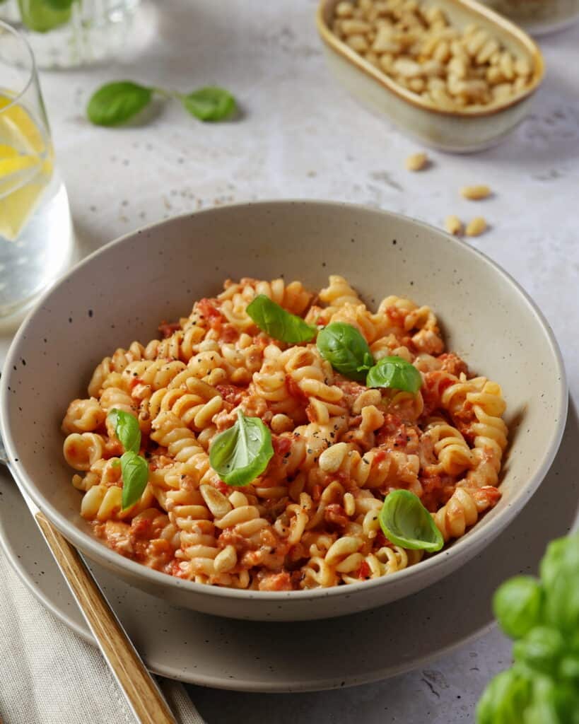 Eine graue Schale mit Pasta mit gerösteter Paprika-Feta-Soße.