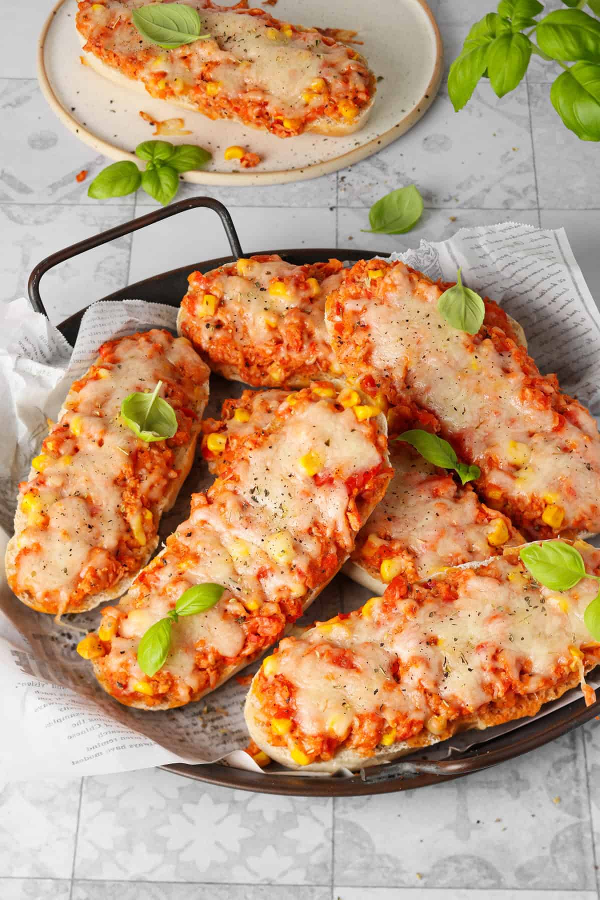 A round dark serving platter filled with delicious baked pizza rolls.
