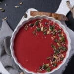 Eine Suppenschale mit Rote-Bete-Suppe, garniert mit Pinienkernen, Sonnenblumenkernen und Kresse.