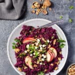 Ein heller Teller mit Rotkohlsalat mit Apfel, Walnüssen und Feta.