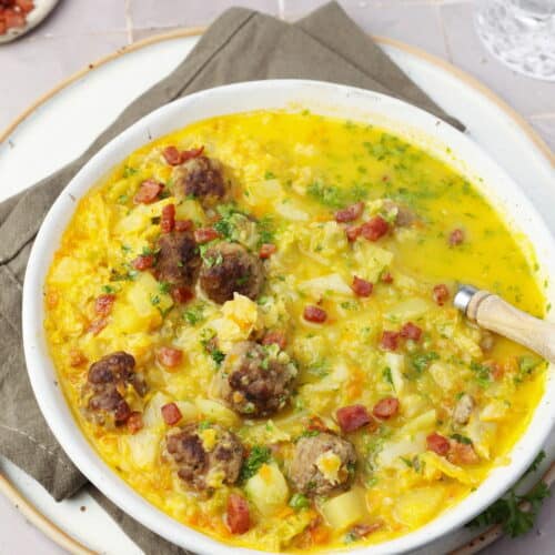 Ein Suppenteller mit Wirsingsuppe mit Hackbällchen.