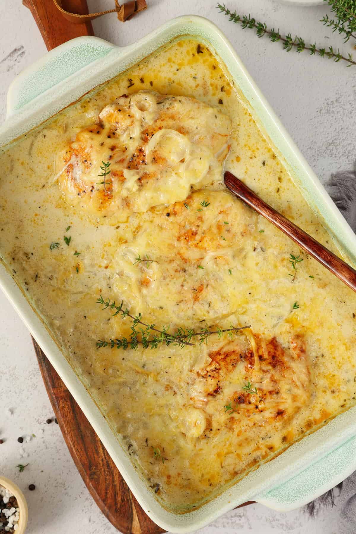 Eine weiße Auflaufform mit Zwiebel-Sahne-Hähnchen.