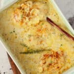 Eine weiße Auflaufform mit Zwiebel-Sahne-Hähnchen.