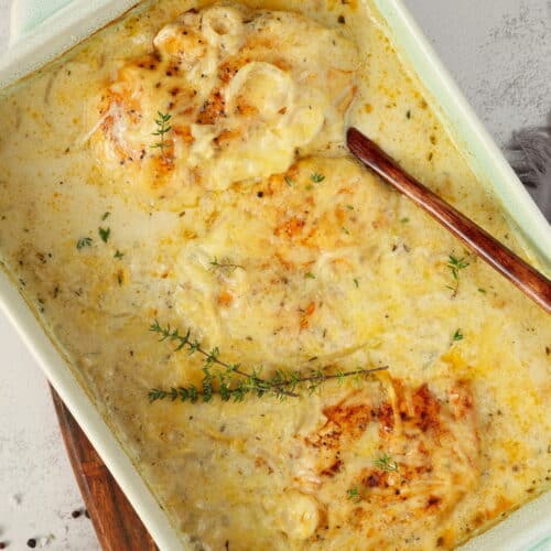 Eine weiße Auflaufform mit Zwiebel-Sahne-Hähnchen.