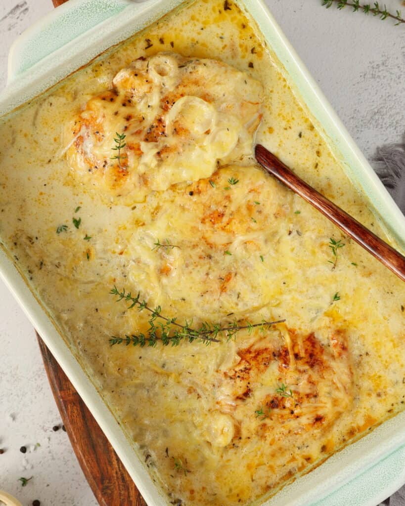 Eine weiße Auflaufform mit Zwiebel-Sahne-Hähnchen.