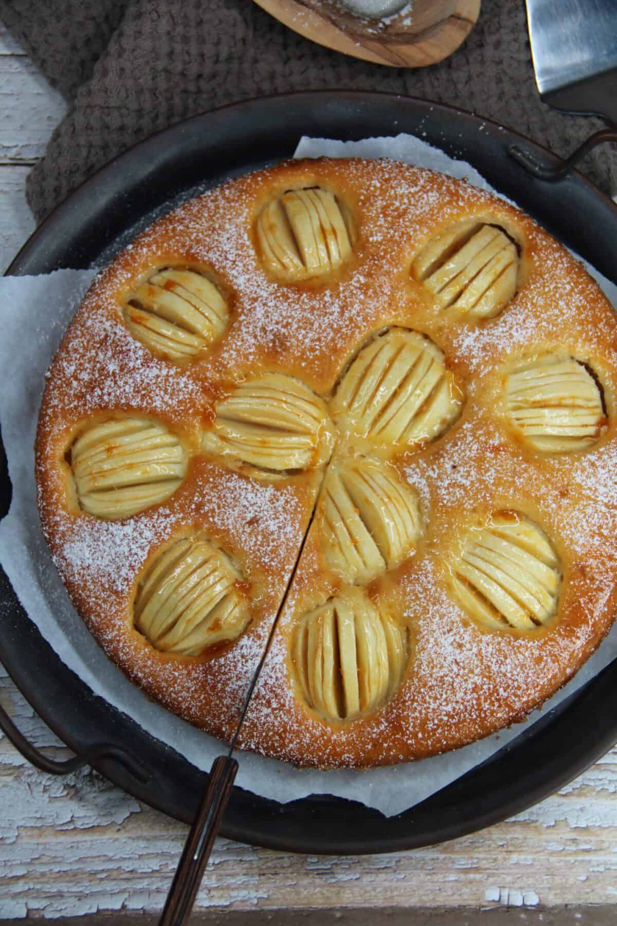 A close-up overhead shot of a whole fresh-baked apple cake.
