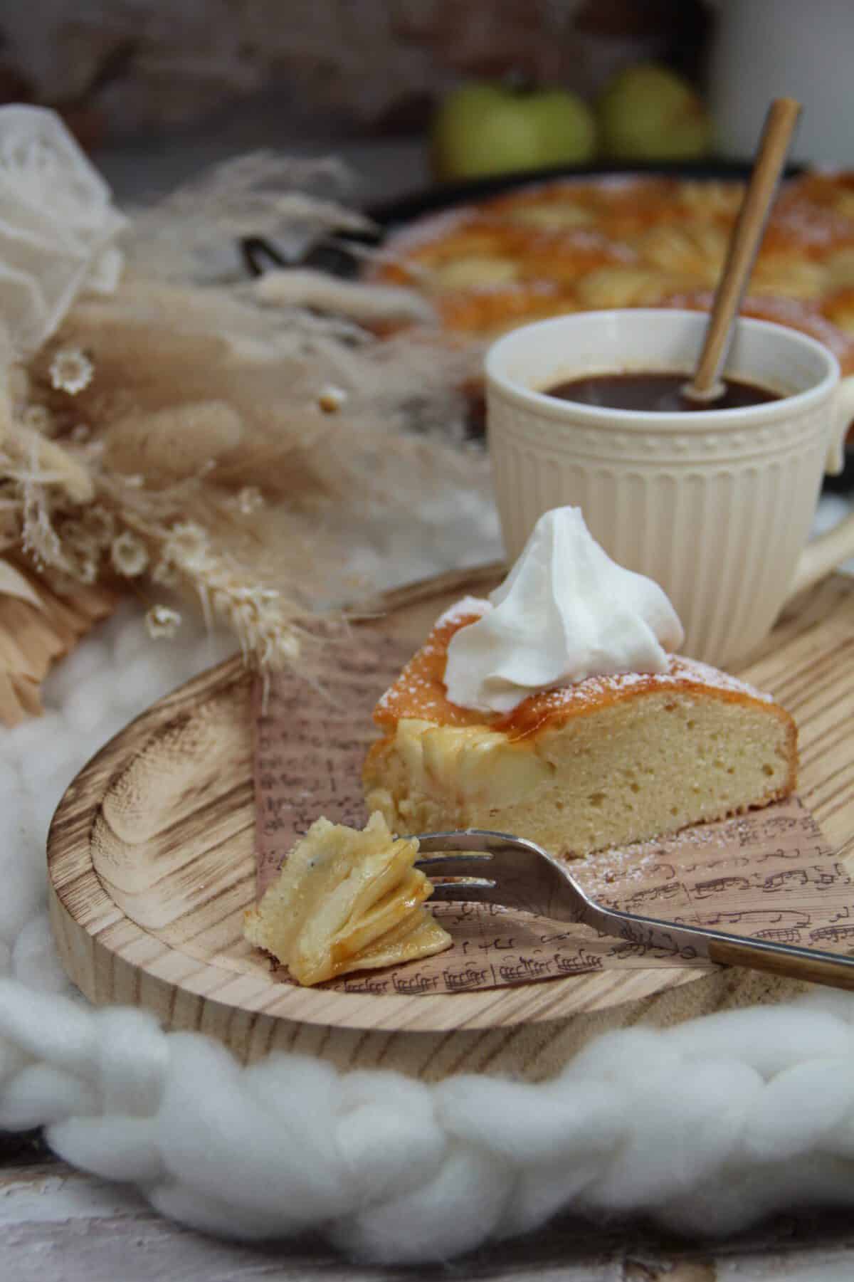 A slice of apple cake on a wooden cutting board.