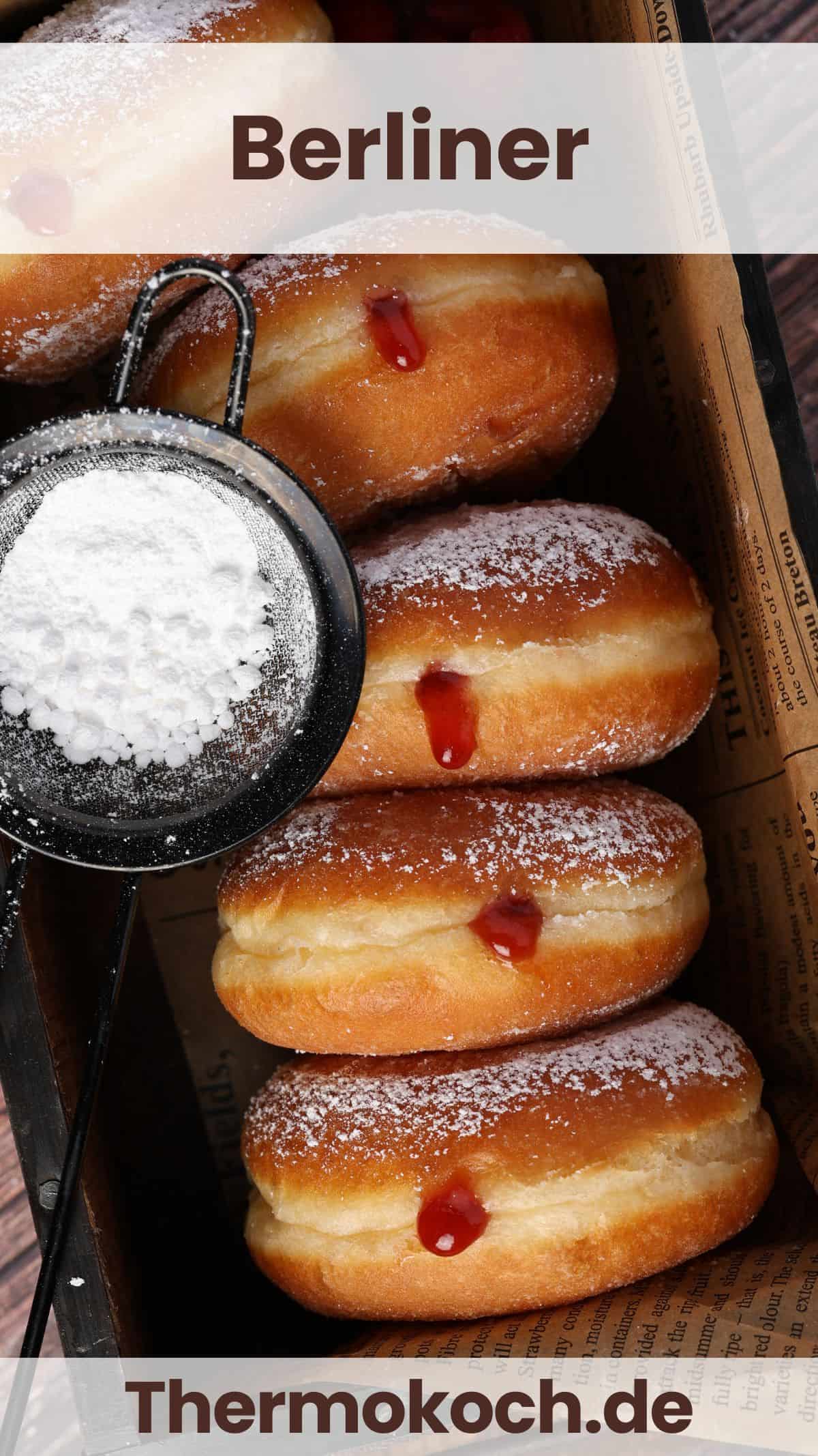 Several Berliners and a small powdered sugar sieve in a rectangular box.
