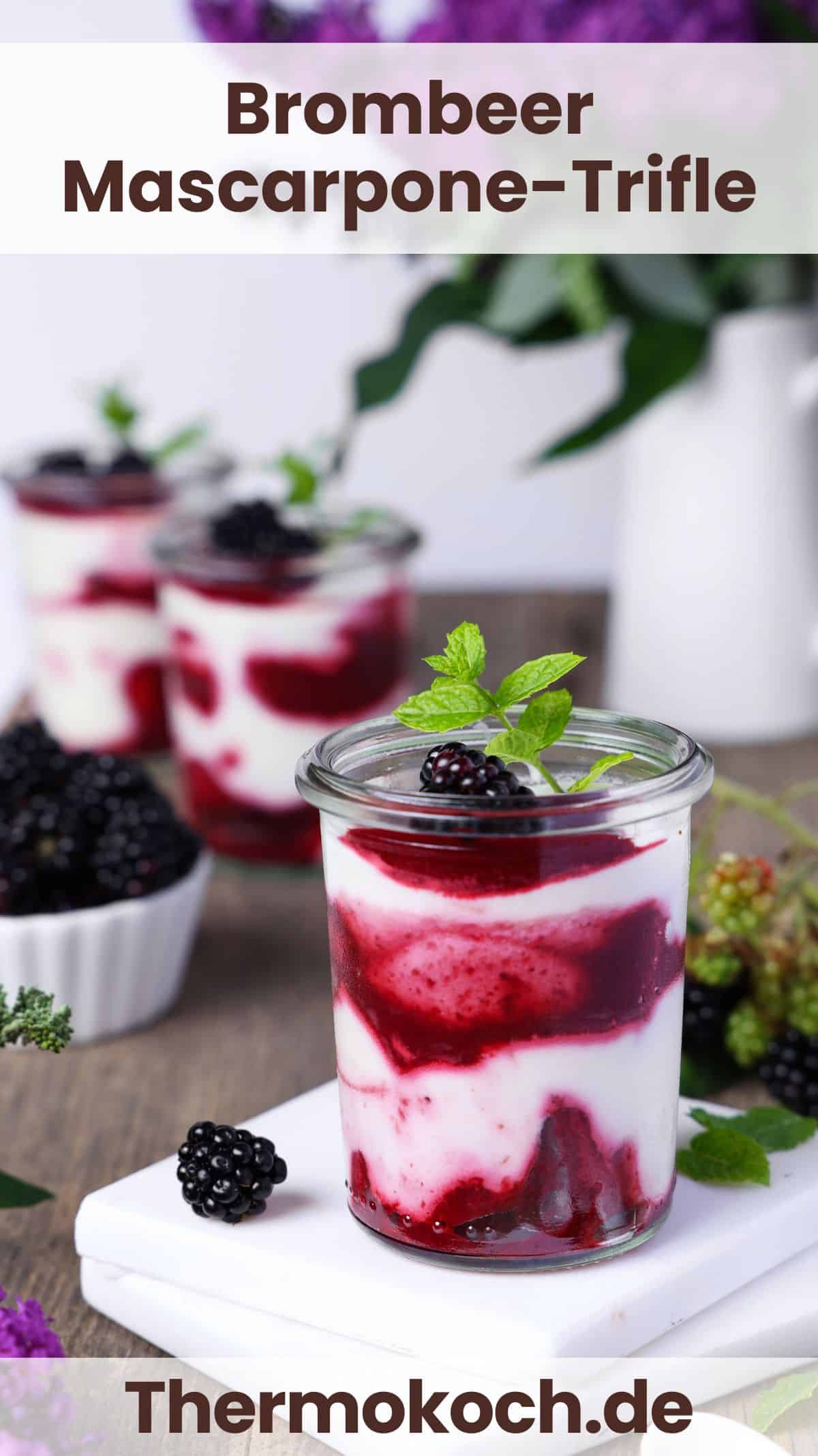 A glass filled with blackberry mascarpone trifle. More glasses with the same dessert are in the background.