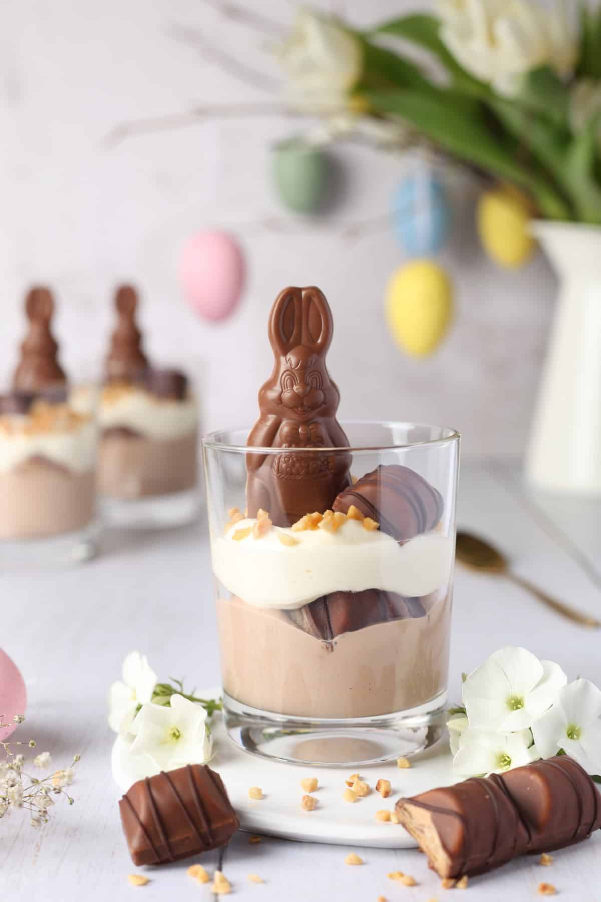 Easter Bueno dessert in a glass with a chocolate bunny, two types of cream, and crispy Bueno pieces.
