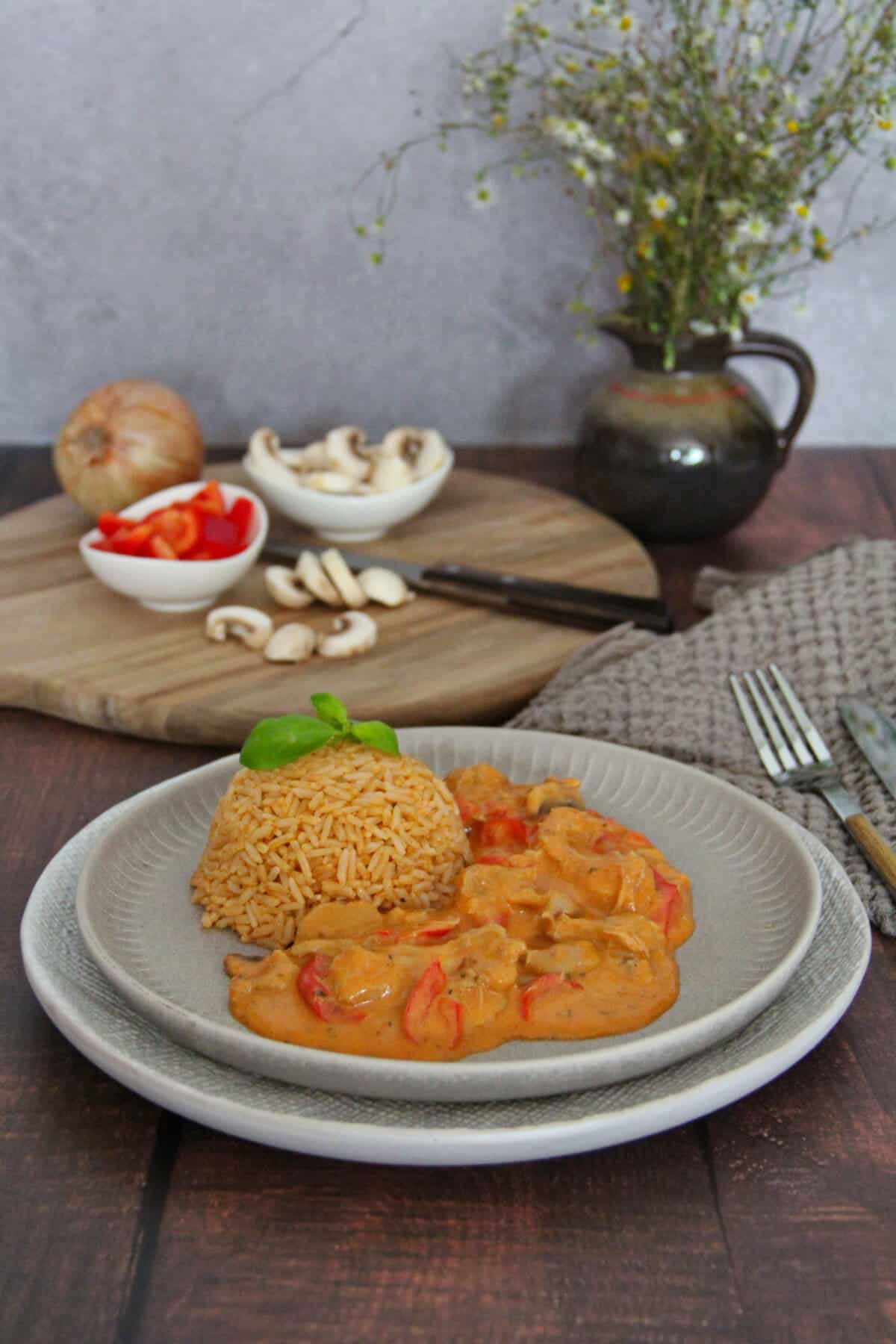 A plate of chicken gyros strips with bell peppers, mushrooms, and rice.