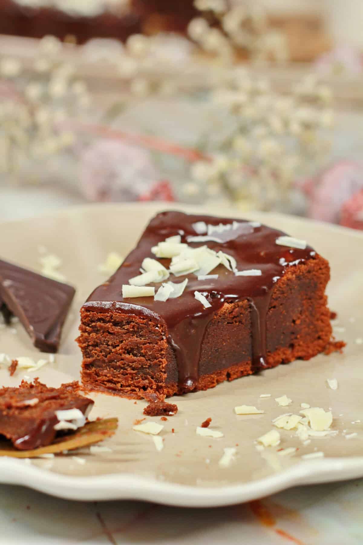 A slice of chocolate cake with a bite taken out on a plate.