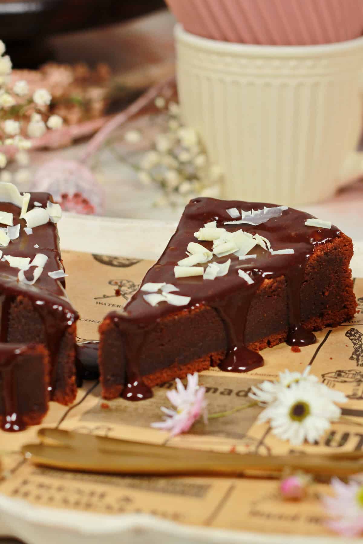 A slice of chocolate cake topped with white chocolate shavings.