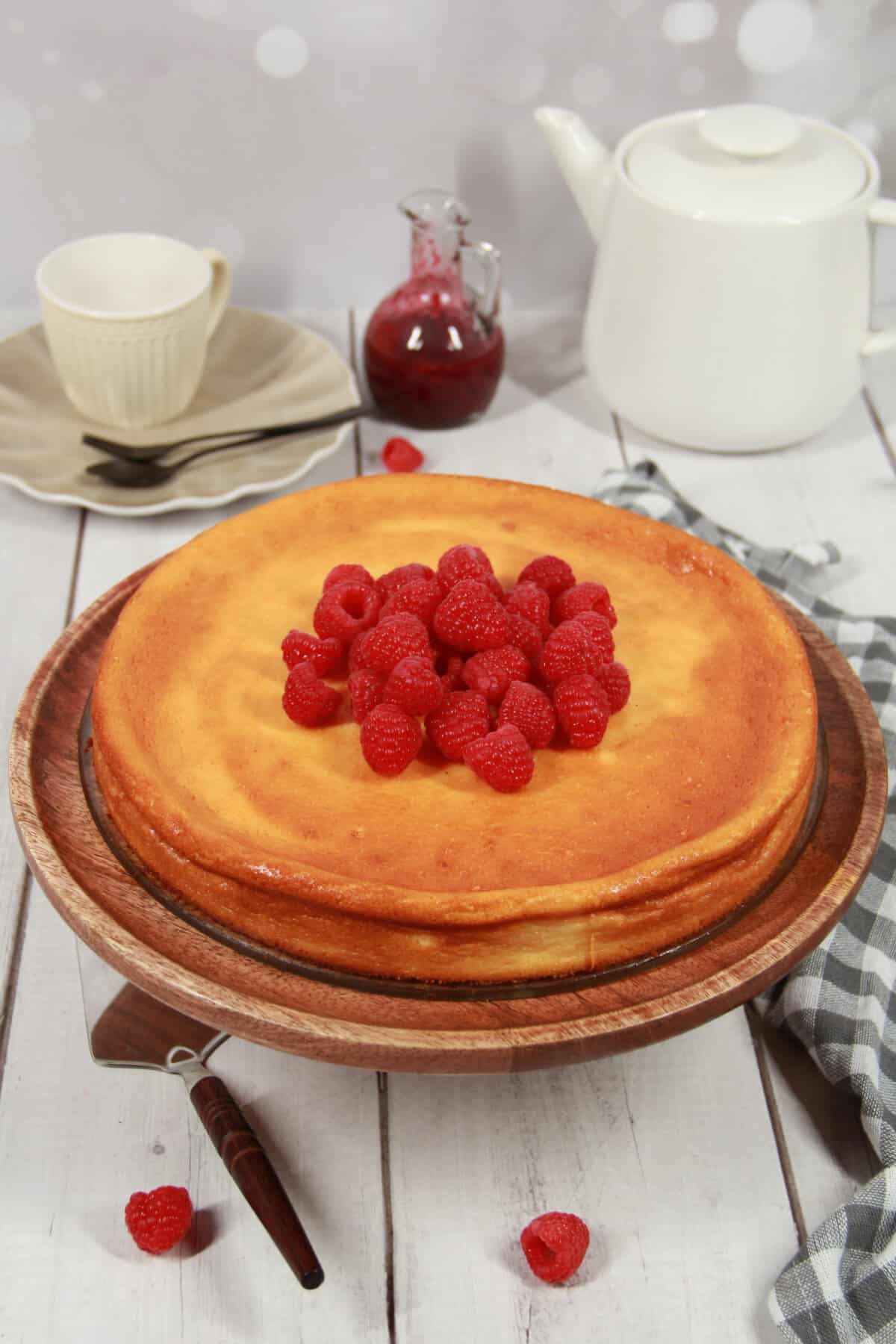 Crustless cheesecake with raspberries on a serving tray.