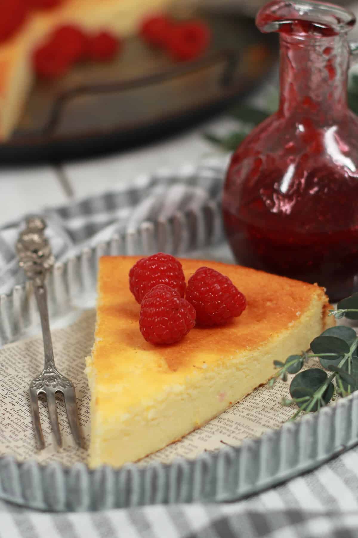 A slice of crustless cheesecake with raspberries.