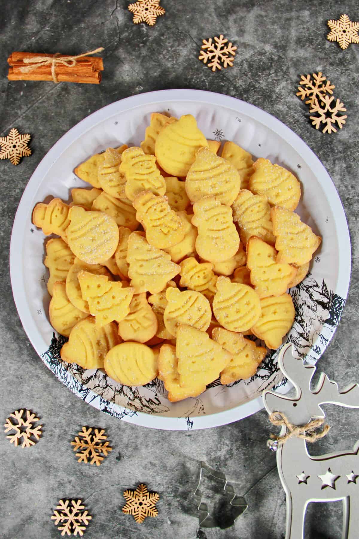 Cut-out Christmas cookies decoratively arranged on a light plate.